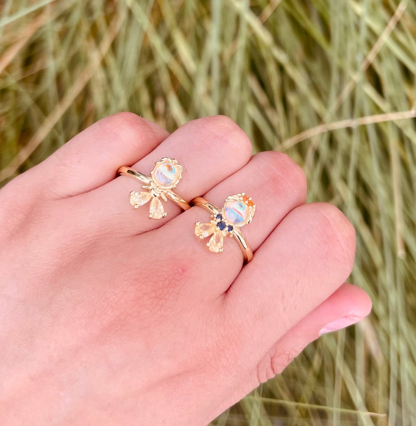 Anillos de fantasía con piedra central iridiscente y gemas de colores