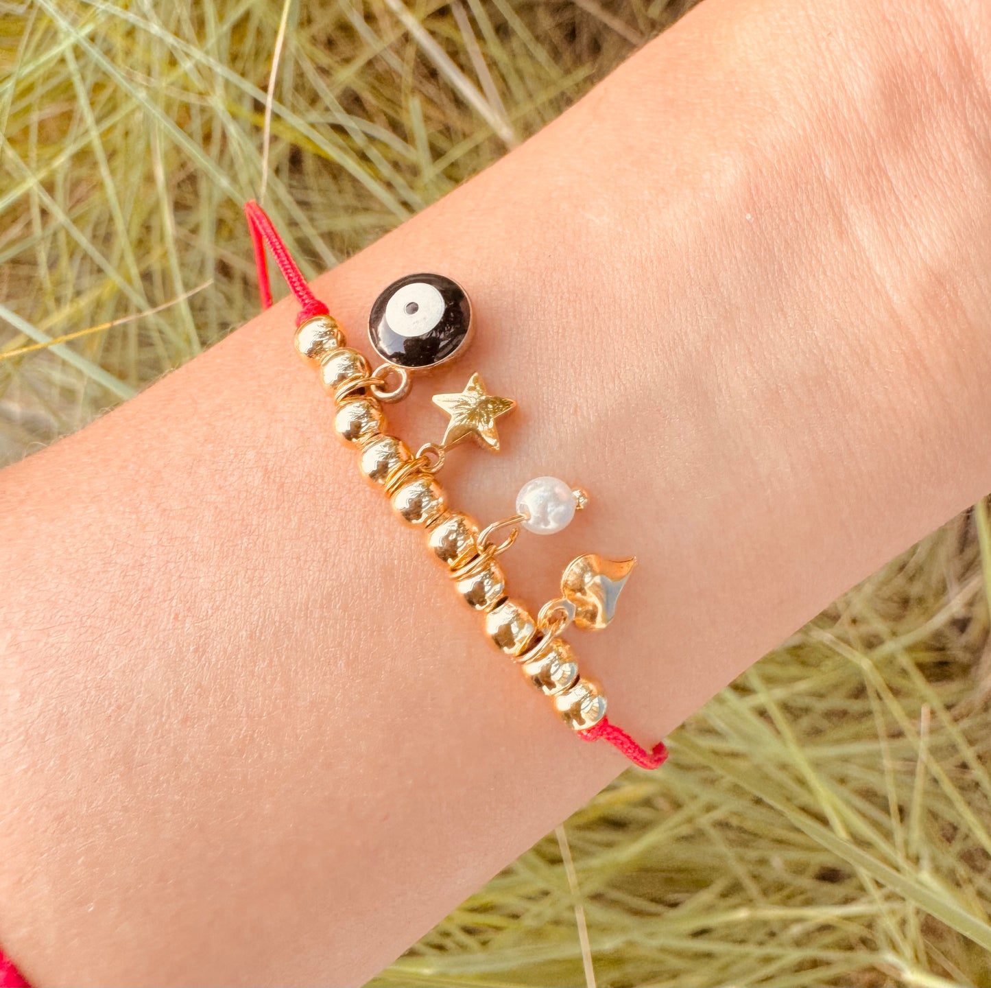 Pulsera Protectora con Hilo Rojo y Dijes Chapados en Oro